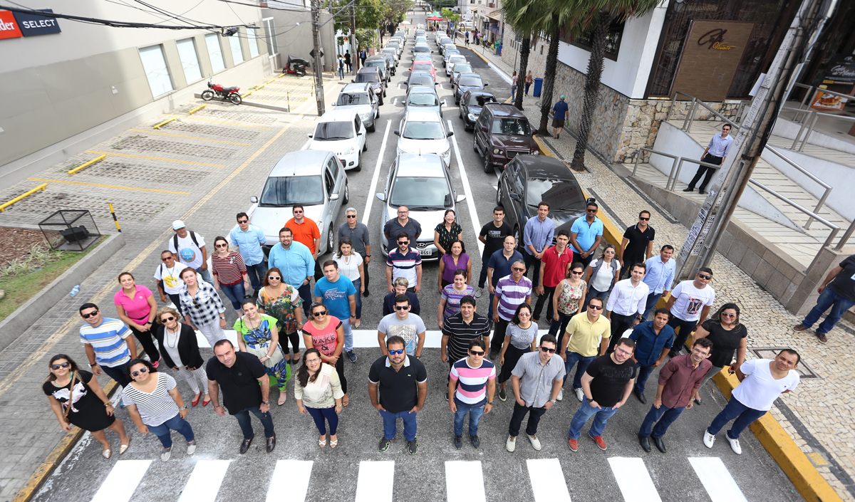 pessoas diante de 40 carros para mostrar quanto espaço os veículos ocupam